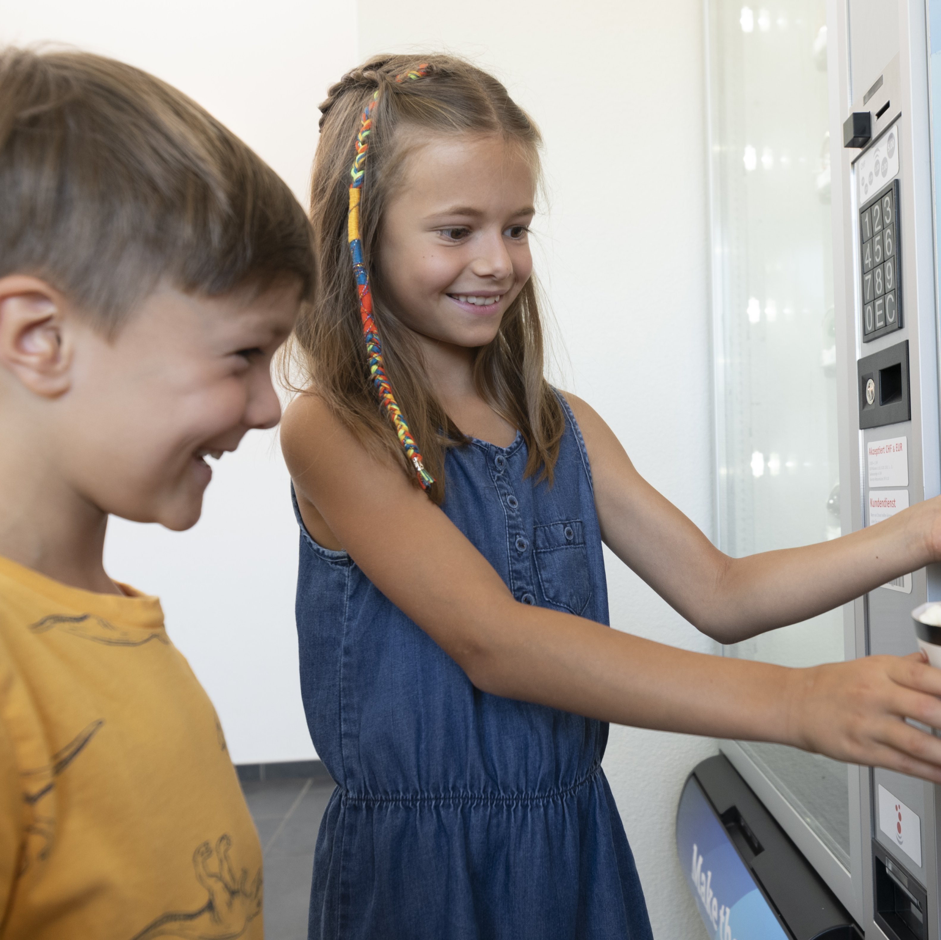 Kinder bedienen sich an der Popcornmaschine