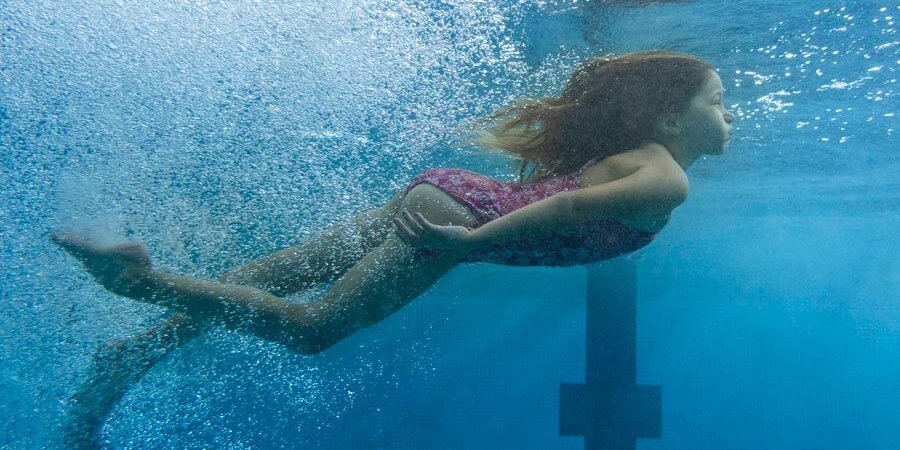 Kind nimmt im Hallenbad an Schwimmkurs für Anfänger teil